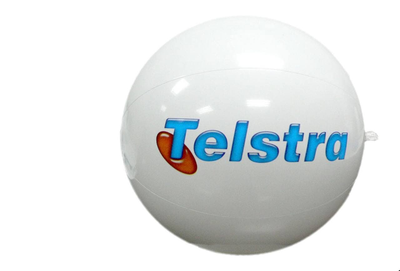 White inflatable beach ball printed with the Telstra wordmark and brand glyph — produced by Sense2.